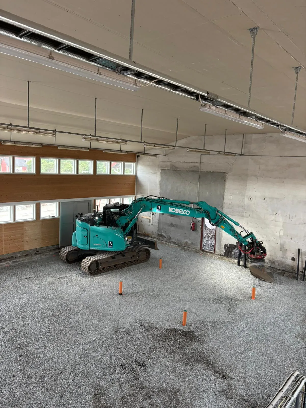 Gravemaskin under innvendig riving i et betongbygg